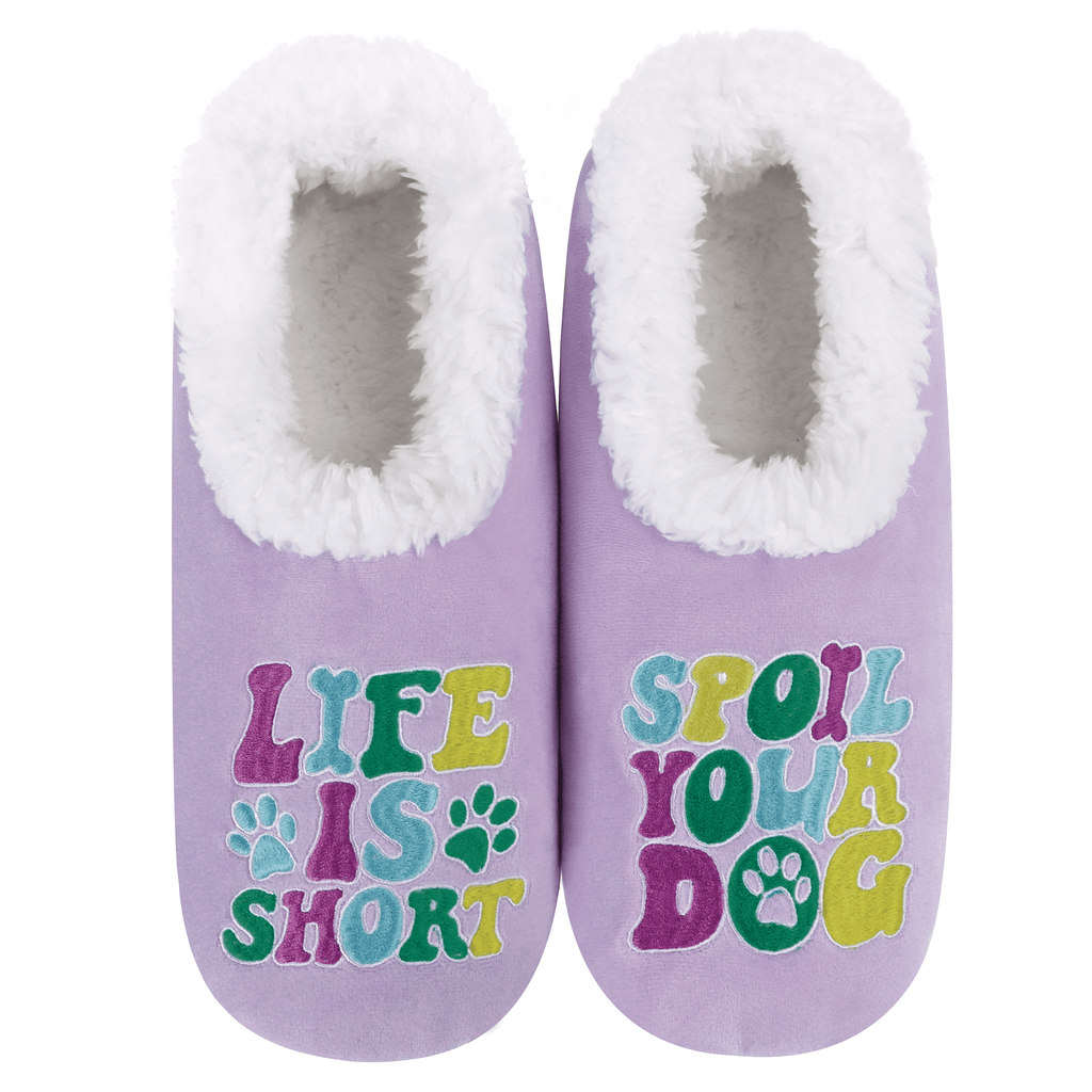 Pair of purple slippers with white fur lining and colorful text: "Life is short, spoil your dog"  on a white background